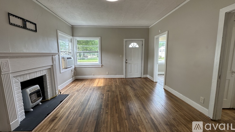 A room with a fireplace and wooden floors is available for rent.