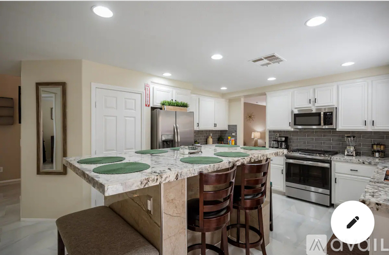 A kitchen with a marble island and stainless steel appliances.