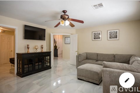 A living room with a grey couch and a black fireplace.