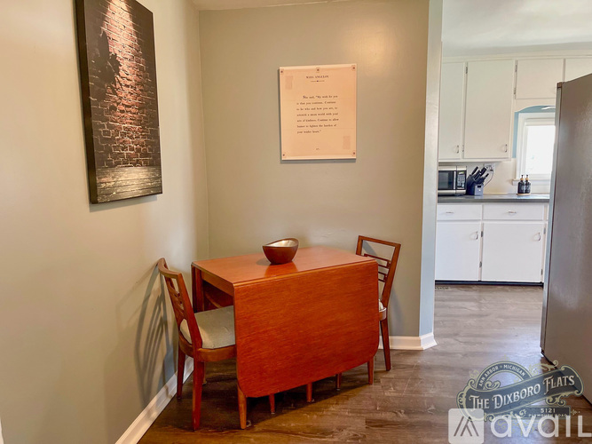 A dining room with a wooden table and chairs.
