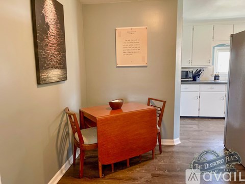 A dining room with a wooden table and chairs.