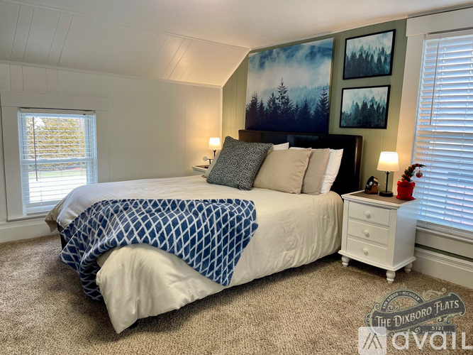 A bedroom with a large bed and a painting on the wall.