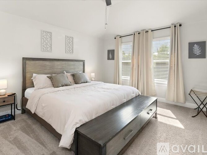 A bedroom with a large bed and a nightstand with a lamp.