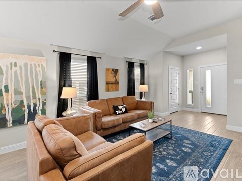 A living room with brown leather couches and a blue rug.