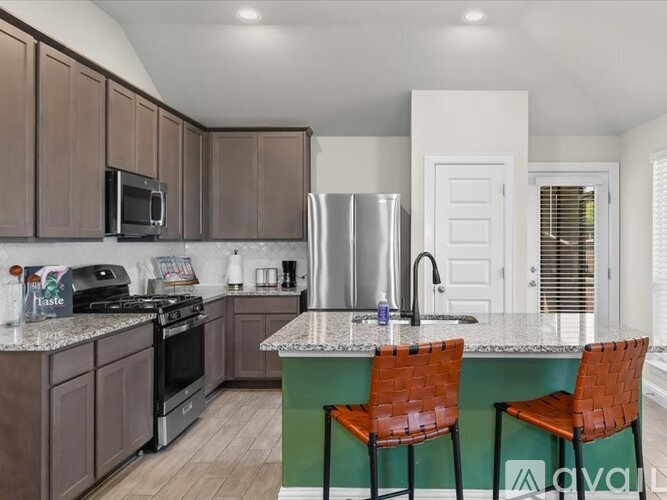 A kitchen with brown cabinets and a green island.