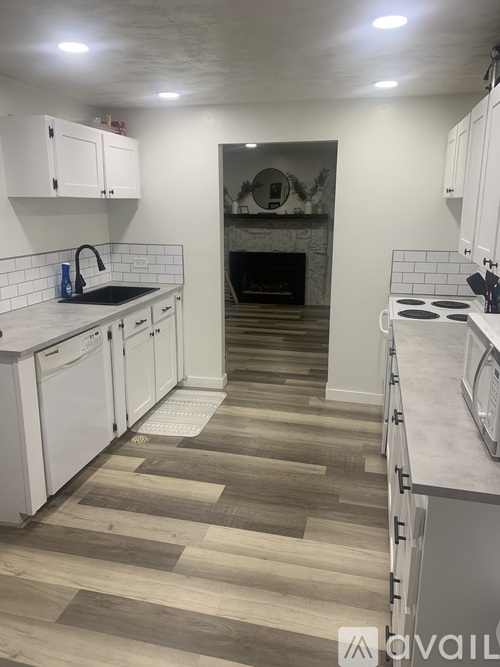 A kitchen with white cabinets and a tile backsplash.