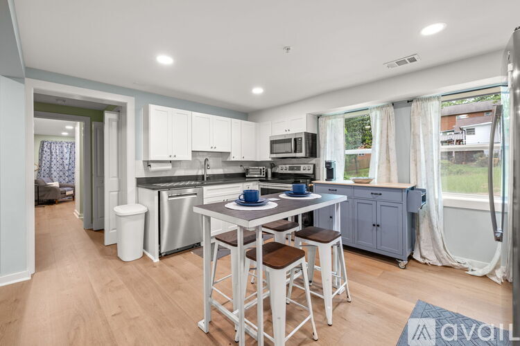 A kitchen with a table and chairs in front of a window.