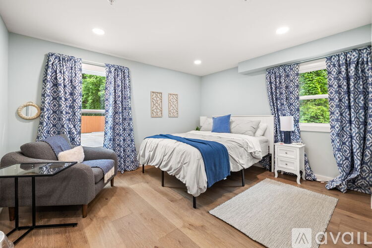 A bedroom with two beds and a chair.