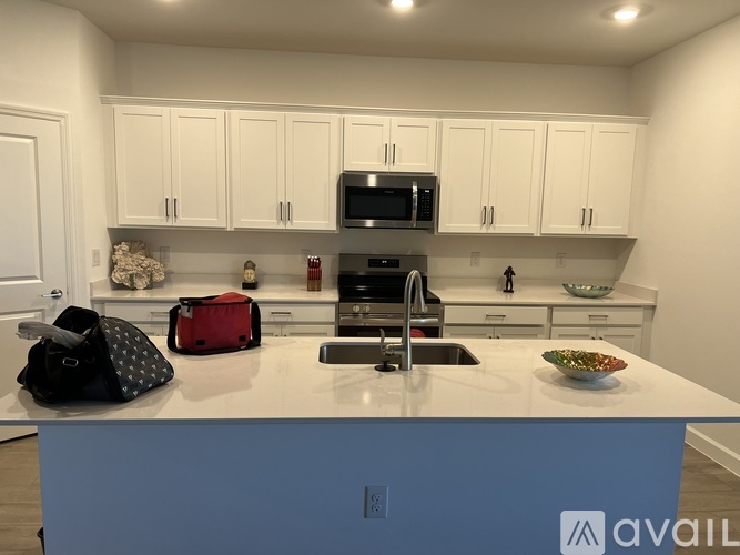 A kitchen with white cabinets and a blue island.