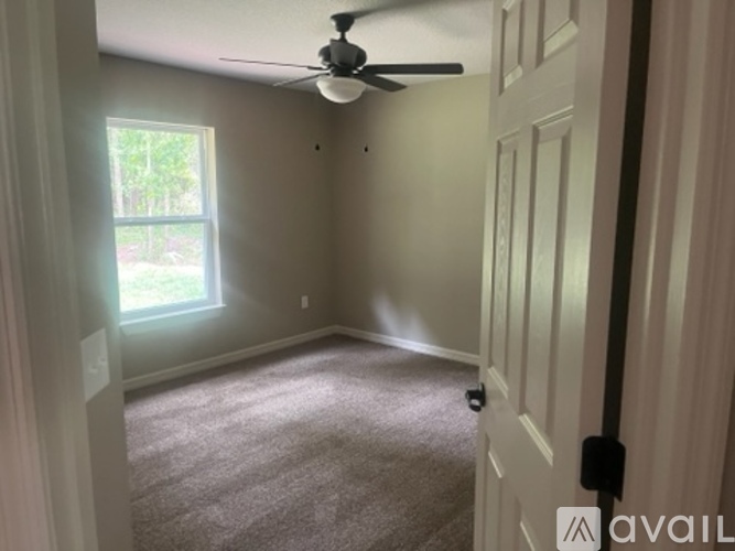 A room with a ceiling fan and a door.