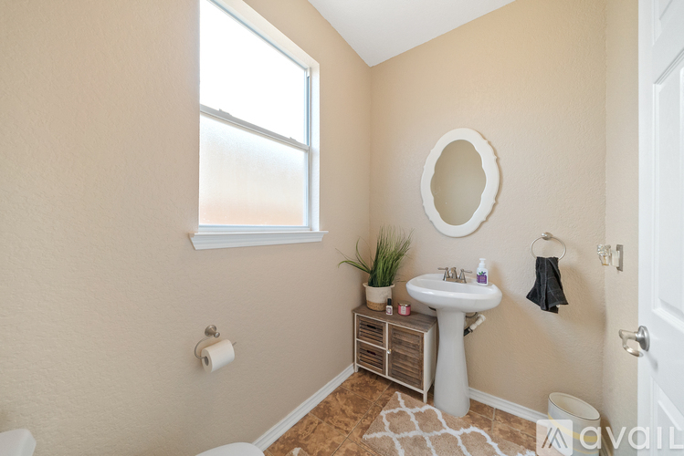 A bathroom with a toilet, sink, and window.