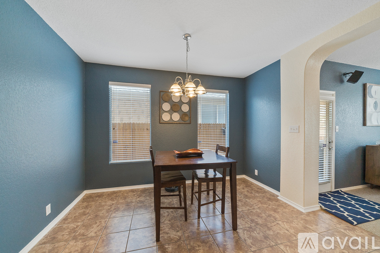 A dining room with a table and chairs.
