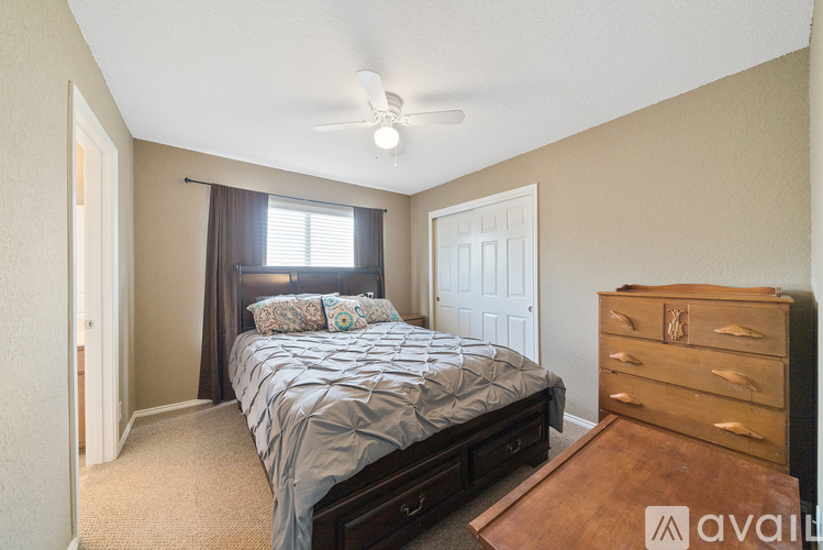 A bedroom with a bed, dresser, and window.