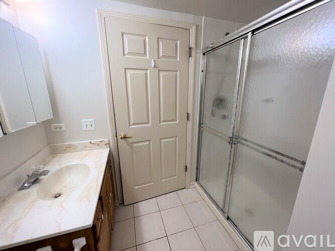 A bathroom with a sink, mirror, and shower.