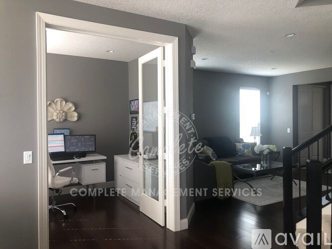 A room with a desk and a couch with a sign that says "Complete Management Services".
