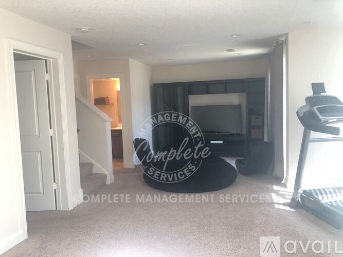 A living room with a couch and a television, with a sign that reads "Complete Management Services".