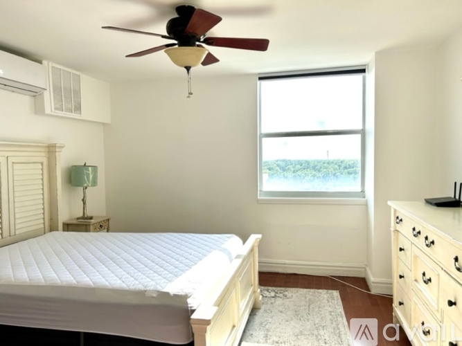 A bedroom with a bed, dresser, and window.