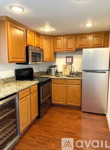 A kitchen with wooden cabinets and a stainless steel refrigerator.