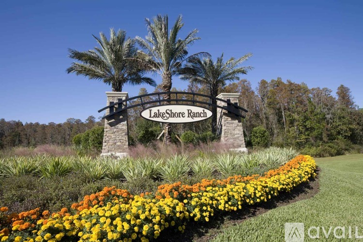 A sign that says Lake Shore Ranch in front of some trees.