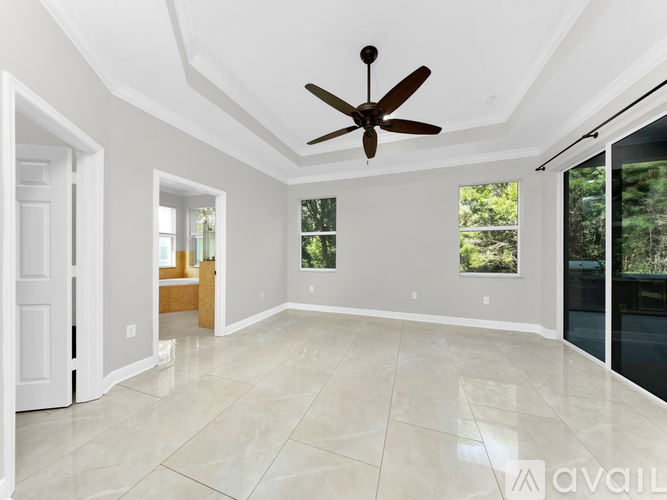 A spacious room with a ceiling fan and sliding glass doors.
