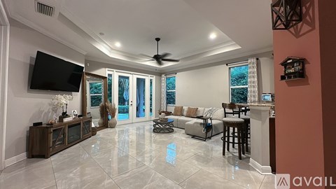 A spacious living room with a flat screen TV mounted on the wall.