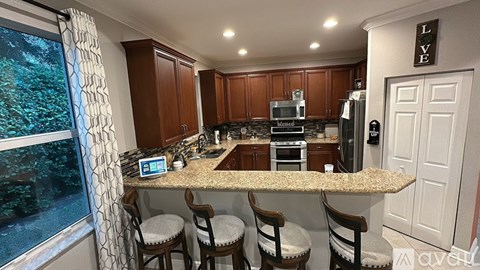 A kitchen with brown cabinets and a granite countertop.