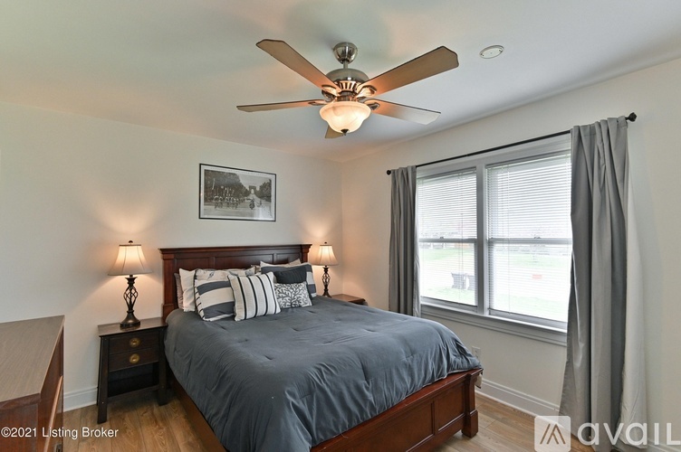 A bedroom with a bed, nightstand, and a ceiling fan.