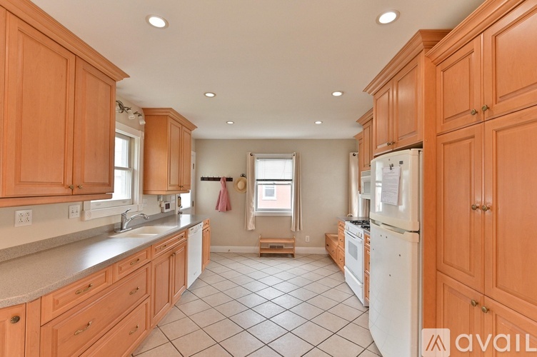 A kitchen with wooden cabinets and a white refrigerator.