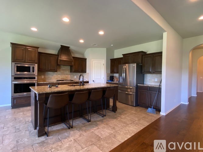 A kitchen with brown chairs and a granite counter top.
