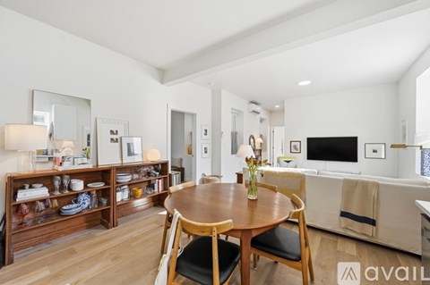 A modern living room with a wooden table and chairs.