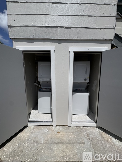 A washing machine and dryer are installed in a small outdoor space.