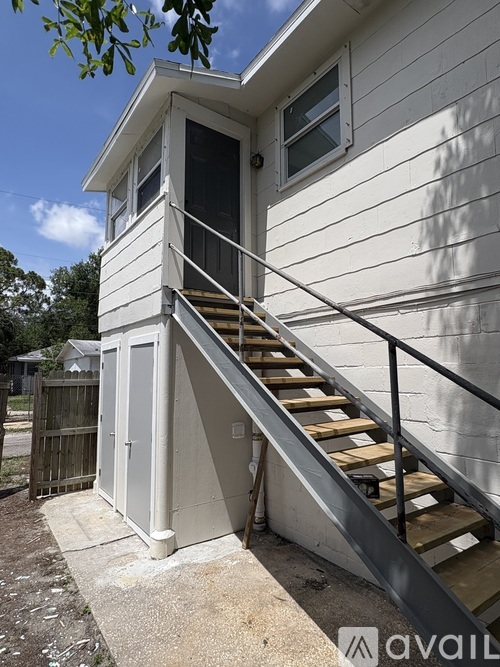 A house with a staircase leading to a small room with a door.