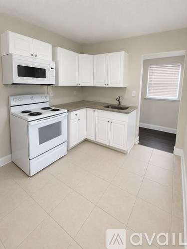 A kitchen with white appliances and cabinets.