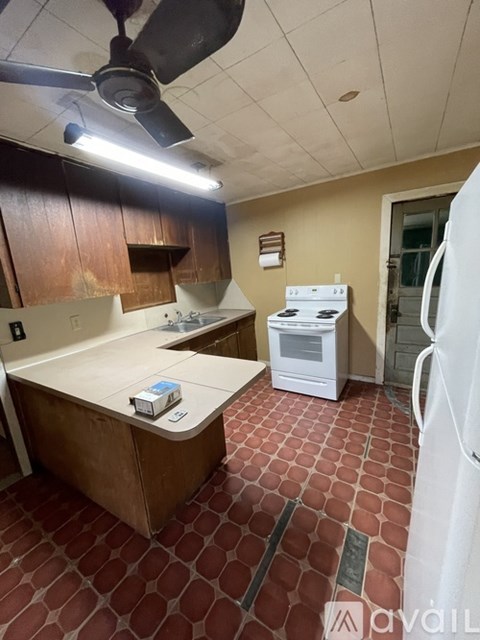 A kitchen with a white fridge, white oven, and a white microwave.