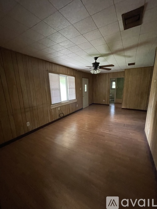 A room with wooden walls and a ceiling fan.