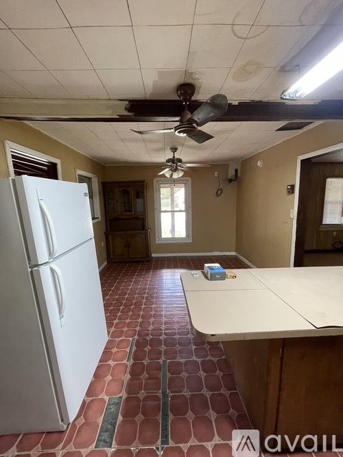 A kitchen with a white fridge and a ceiling fan.