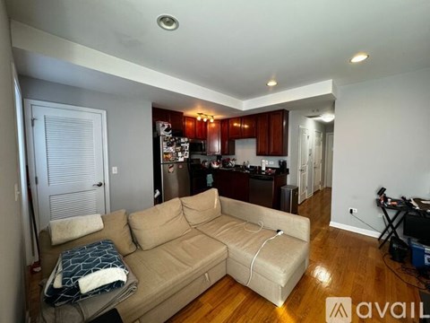 A living room with a couch and a kitchen in the background.