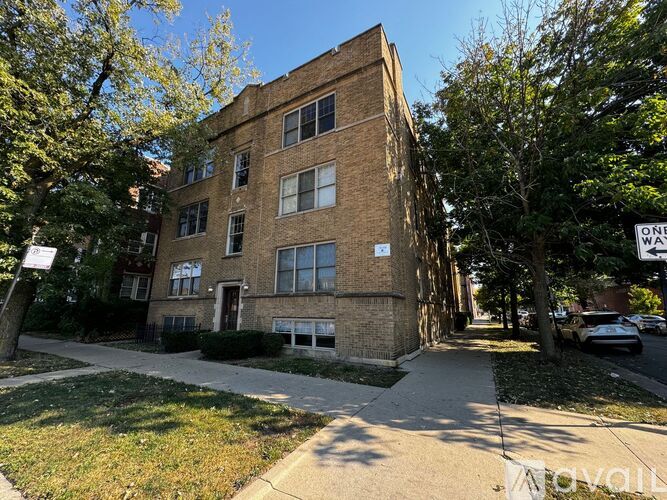 A tall brick building with a sign that says "One Way" on the street in front of it.