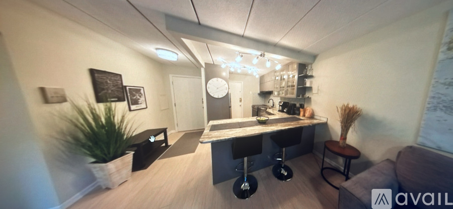 A kitchen area with a bar stool and a counter.