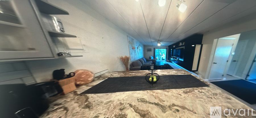 A room with a bed in the middle and a couch in the background.