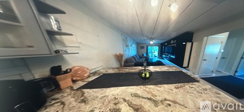A room with a bed in the middle and a couch in the background.
