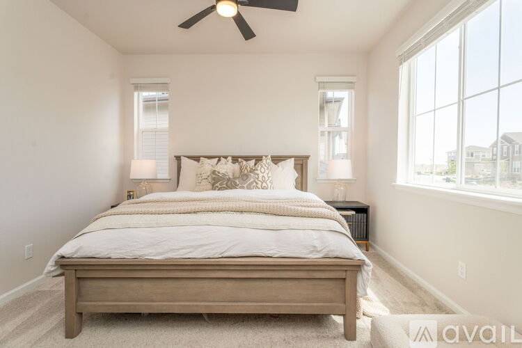 A bedroom with a large bed and a ceiling fan.