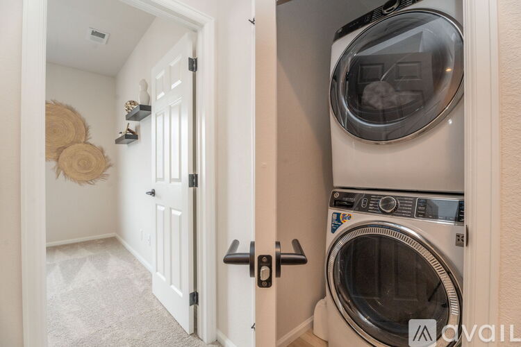 A washing machine is in a small space between two doors.