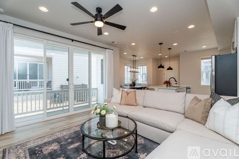 A living room with a white couch and a glass coffee table.
