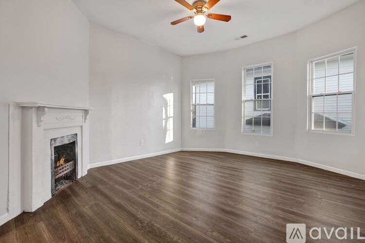 A room with a fireplace and a ceiling fan.