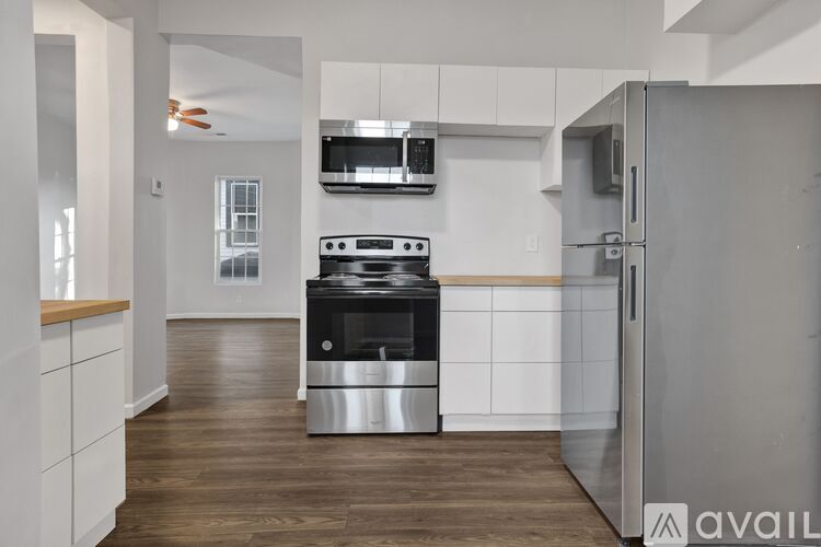 A modern kitchen with a stainless steel refrigerator and a black stove top oven.