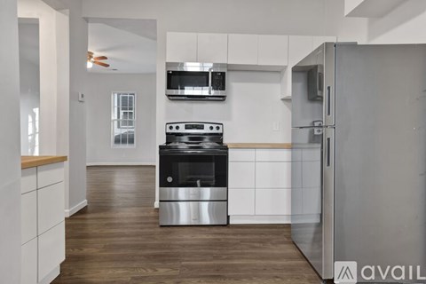 A modern kitchen with a stainless steel refrigerator and a black stove top oven.