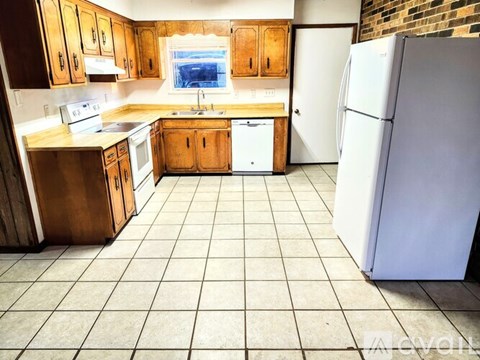 A kitchen with wooden cabinets and a white refrigerator.