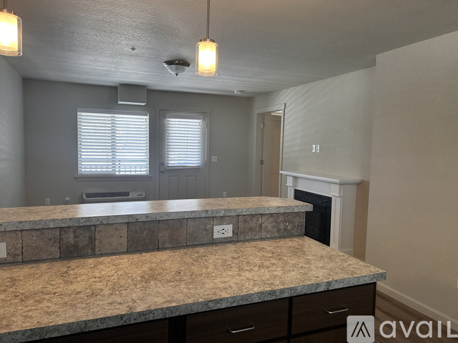 A kitchen with granite countertops and a window with blinds.
