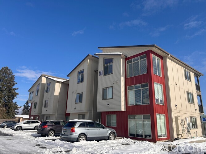 Apartment building with cars parked in front.